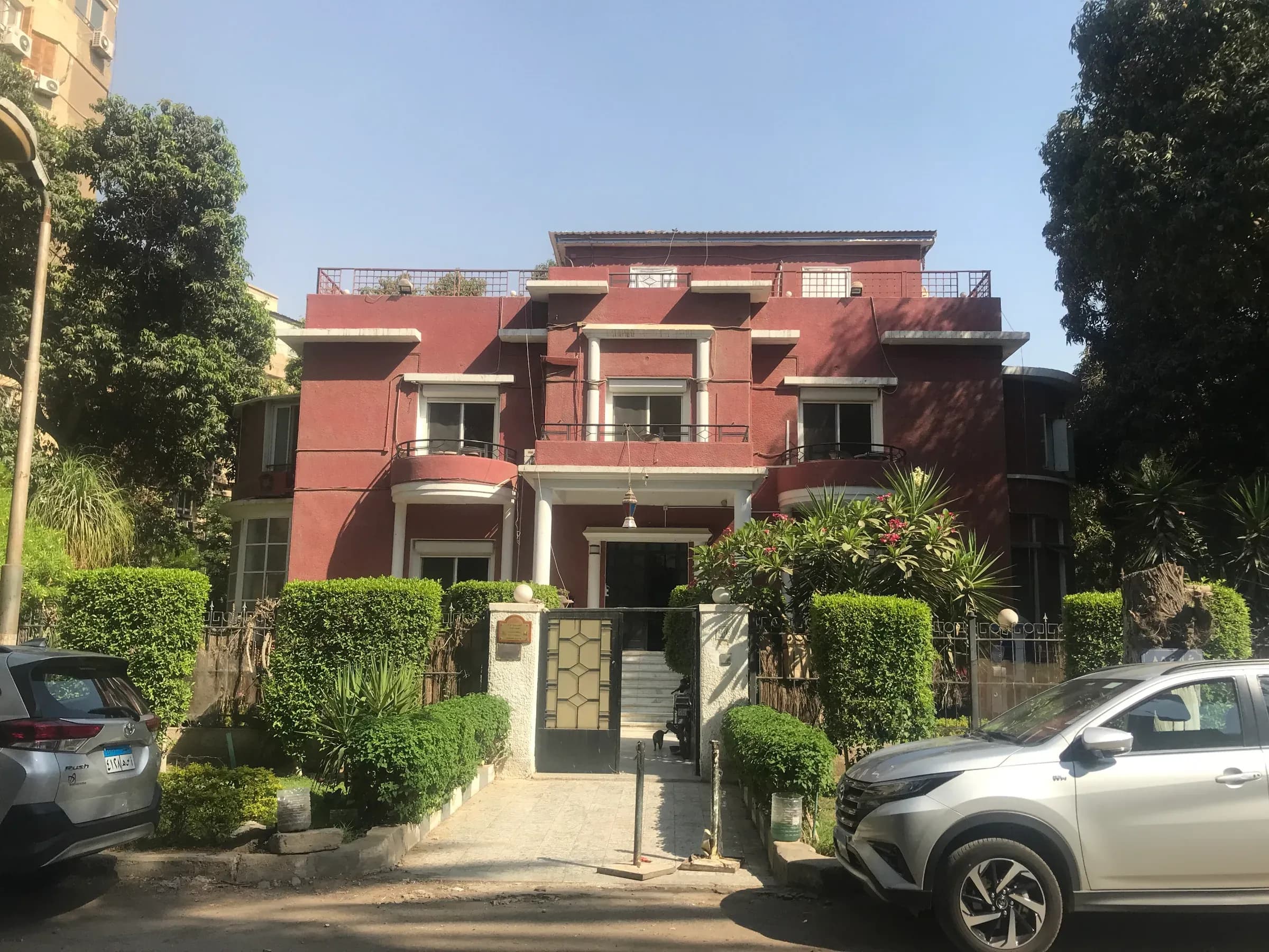 Villa Debussy, a red-and-cream villa behind a leafy garden on Street 85 in Maadi, Cairo